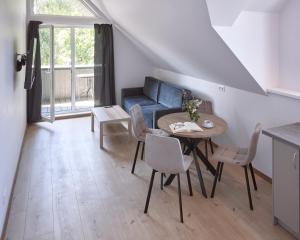 a living room with a table and chairs and a couch at Jūros terasos in Šventoji