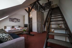 a living room with a staircase and a couch at Hotel Churáňov in Stachy