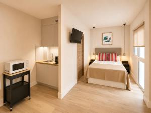 a hotel room with a bed and a microwave at 10ToSea Premium Hostal in Fuengirola