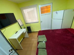 a room with a bed and a desk and a television at Candil in Neuquén
