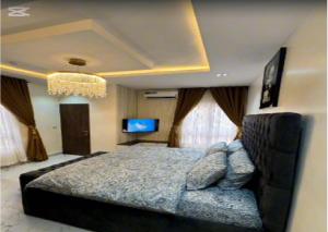 a bedroom with a large bed and a tv at De Crystal Place in Ikate