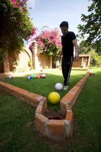 a man standing next to a brick wall with balls at Lumbai Glamping Mazamitla in Mazamitla