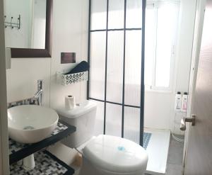 a white bathroom with a toilet and a sink at Apartamento Libertad in Elda +7 photos