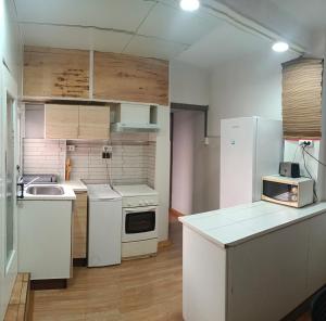 a kitchen with white appliances and wooden floors at Apartamento Libertad in Elda