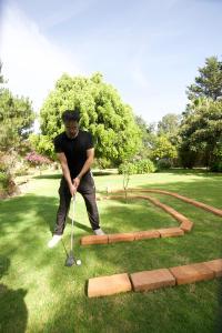a man is playing golf in the grass at Lumbai Glamping Mazamitla in Mazamitla