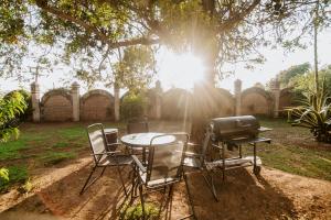 a table and chairs and a grill under a tree at Lumbai Glamping Mazamitla in Mazamitla