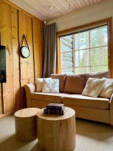 a living room with a couch and two logs at Silver Lodge in Luosto