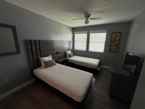 a bedroom with two beds and a desk with a tv at Villas at Fortune Place in Kissimmee +20 photos