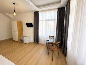 a room with a table and chairs and a window at Hotel Danja in Laç