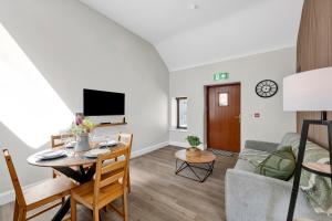a living room with a table and a couch at Millmaster Apartment in Drumahayre