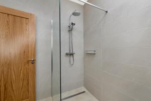 a shower with a glass door in a bathroom at Millmaster Apartment in Drumahayre +10 photos