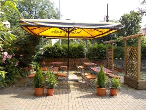 a patio with a table and chairs and an umbrella at Zur Alten Brauerei in Jessen