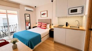 a bedroom with a bed and a kitchen with a sink at 10ToSea Premium Hostal in Fuengirola