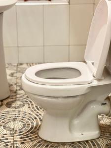 a white toilet with the seat up in a bathroom at Kisoro Suits in Kisoro