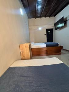a bedroom with two beds and a tv in it at Hotel Imperio Real Medellin in Medellín