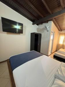 a bedroom with a bed and a tv on the wall at Hotel Imperio Real Medellin in Medellín