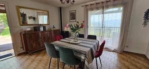 a dining room table with chairs and a vase of flowers at Gîte Xuritenborda 7 personnes avec vue exceptionnelle sur les montagnes basque, Lits 180 King Size in Ossès