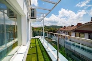 an outdoor balcony with a view of the yard at Central Summer Theatre Suites in Veliko Tŭrnovo