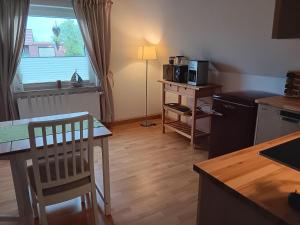 a kitchen with a table and chairs and a kitchen with a window at Heringsmoewe in Tossens
