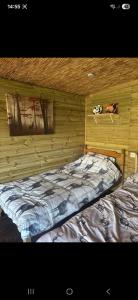 a bedroom with a bed in a wooden wall at The Mid Devon Retreat in Crediton
