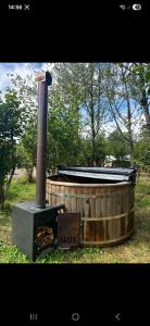 a woodburning stove sitting in a field with trees at The Mid Devon Retreat in Crediton