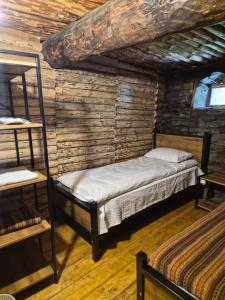 a bedroom with two beds in a log cabin at Hotel Front Castle in Shatili