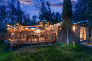 a house with a deck with lights on it at Halfling House w/hot tub/firepit/more! in Coarsegold