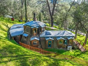 a small house with a blue roof on a hill at Halfling House w/hot tub/firepit/more! in Coarsegold