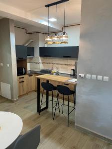 a kitchen with two bar stools and a counter top at DREAM house in Paraćin