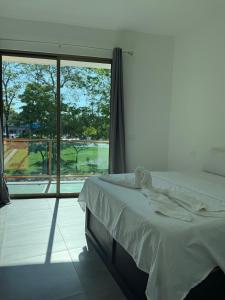 a bedroom with a bed and a large window at Hotel kleos in Cárdenas