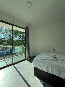 a bedroom with a bed and a large window at Hotel kleos in Cárdenas