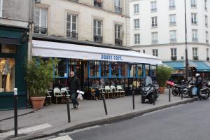 a street corner with a store with a motorcycle parked in front at Appartement cœur de la bastille in Paris