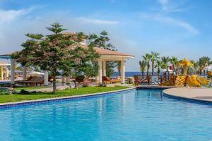 a swimming pool at a resort near the ocean at Royal Brayka Beach Resort in Marsa Alam City