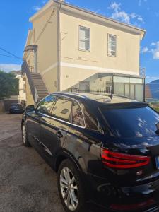 a black car parked in front of a house at locazione turistica da Iole in Popoli