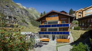 a building with a blue trim and a mountain at Chalet Sonnegg in Zermatt