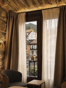 a window with a view of a city at Apartamentos El Capitan in Potes +10 photos