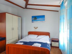 a bedroom with a bed with a blue blanket at Guest House Frane in Pag