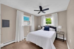 a white bedroom with a bed and a ceiling fan at Between Tides 2BR Walk to Beach Unit B in Seaside Park