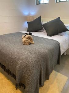 a large bed with a towel on top of it at The Cabernet Cottage - One Bedroom in Table View