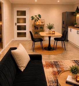 a living room with a couch and a table at The Cabernet Cottage - One Bedroom in Table View