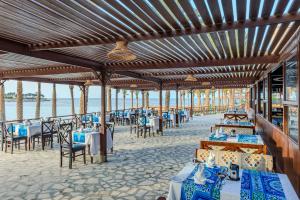 a restaurant on the beach with tables and chairs at Royal Brayka Beach Resort in Marsa Alam City