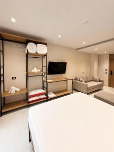 a bedroom with a bed and a couch and a tv at Blester Hotel Golem Durres in Golem