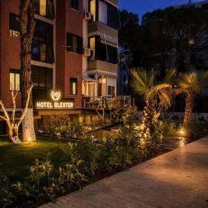 a hotel exterior with a hoteliger sign at night at Blester Hotel Golem Durres in Golem