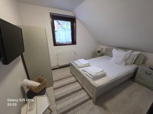 a small bedroom with a bed and a television at Pensiunea Daria Putna in Putna