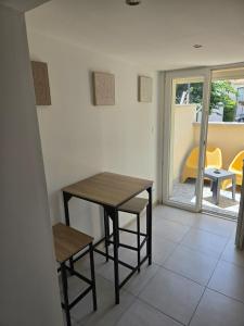 a table and stool in a room with a table and chairs at small and cozy in Perpignan +6 photos