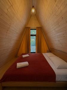 a bedroom with a red bed in a attic at Garden Cottages in Mestia