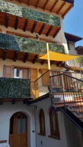 a house with a balcony and a door and stairs at Casa Sole in Ceniga