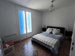 a bedroom with a bed and two large windows at Maison Éléphantaisie in Salies-de-Béarn