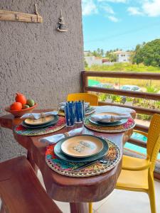 a table with plates and bowls of fruit on a balcony at Studio Patacho Rota dos Milagres in Pôrto de Pedras