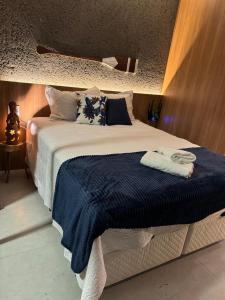 a bedroom with a large bed with a blue blanket at Studio Patacho Rota dos Milagres in Pôrto de Pedras +59 photos